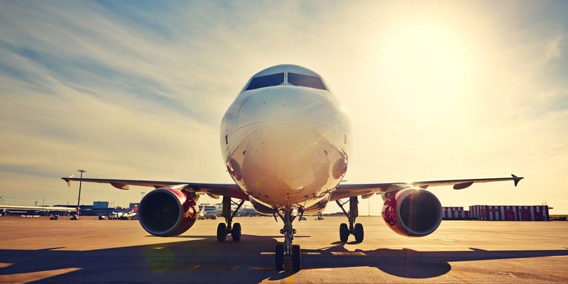 front view of aeroplane on runway in morning sun