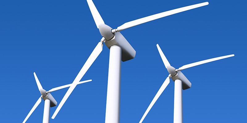 top section of 3 wind turbines against blue sky