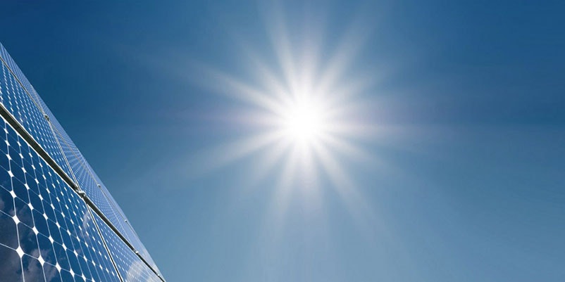 4 solar panels with bright sun in background
