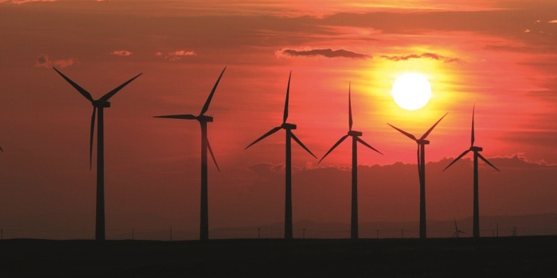 silhouette of 6 wind turbines at sunset
