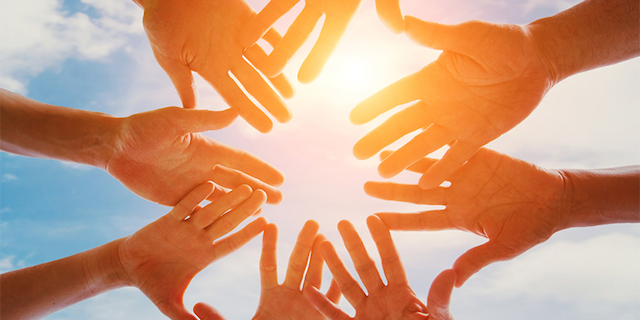 volunteering climate change photo looking at underside of hands joined in front of sun
